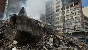 Bombeiros iniciam buscas com máquinas pesadas em edifício que desabou