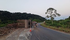 Caminhão carregado com toras de madeira tomba na AL-413 e condutor fica ferido