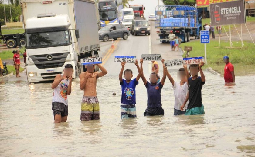 Risco: jovens entram em água da chuva para resgatar placas de veículos no Pilar
