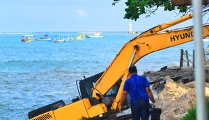 Maré avança e deixa parte de retroescavadeira submersa na orla de Ponta Verde