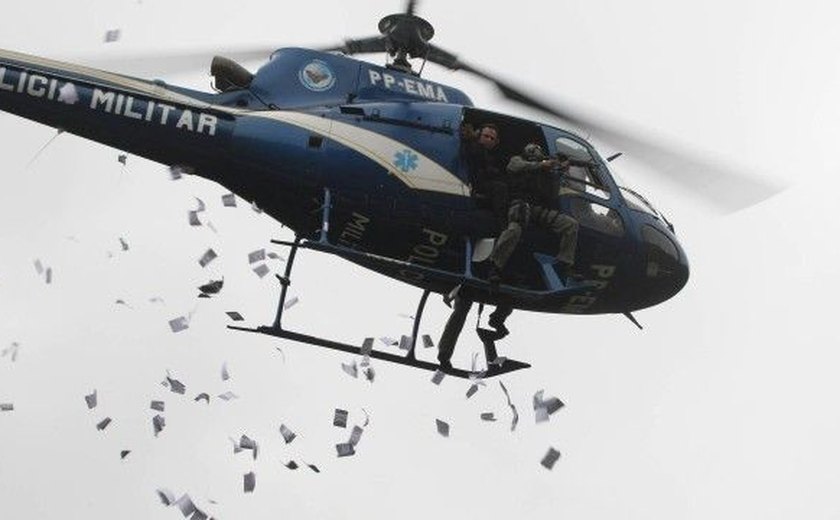 Helicóptero das forças de segurança lança panfletos na Rocinha
