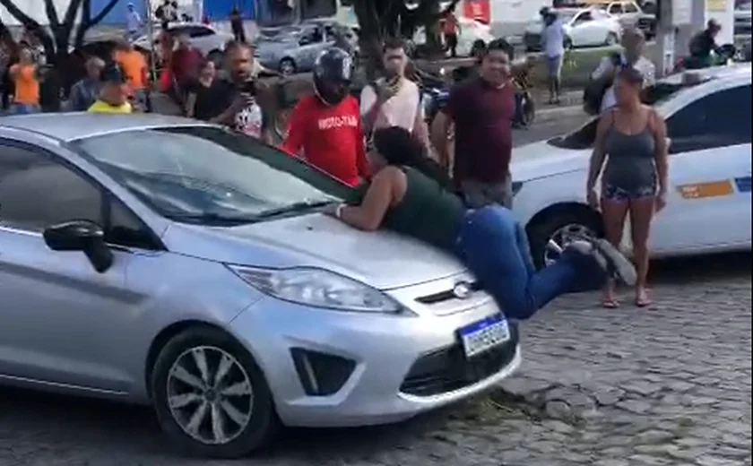 Mulher flagra companheiro com suposta amante e se joga em capô de veículo