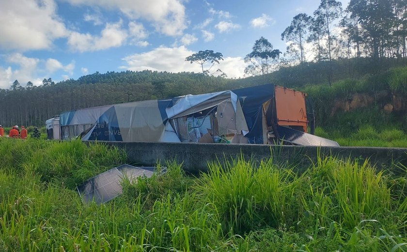 Carreta carregada com placas solares tomba na BR-101 em Messias; duas pessoas ficam feridas