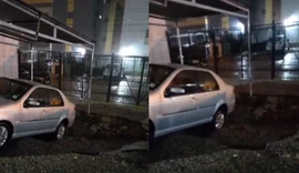 Traseira de carro fica presa em cratera formada em estacionamento de condomínio residencial