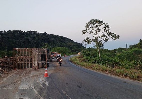 Caminhão carregado com toras de madeira tomba na AL-413 e condutor fica ferido