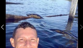 Jovem arrisca 'selfie' com cobra anaconda em rio no AM, e foto viraliza