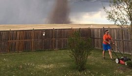 Homem corta grama tranquilamente durante passagem de tornado no Canadá