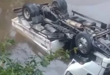 Caminhão caçamba cai em rio após colisão na BR-104, em Murici