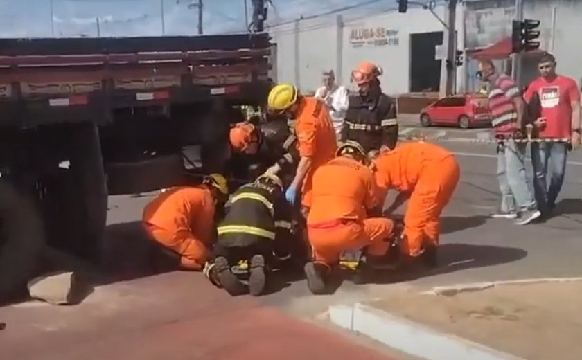 Motociclista fica preso às ferragens embaixo de caminhão após colisão