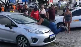 Mulher flagra companheiro com suposta amante e se joga em capô de veículo