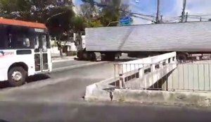 Condutor de caminhão faz manobra arriscada e derruba grade e mureta da Leste-Oeste