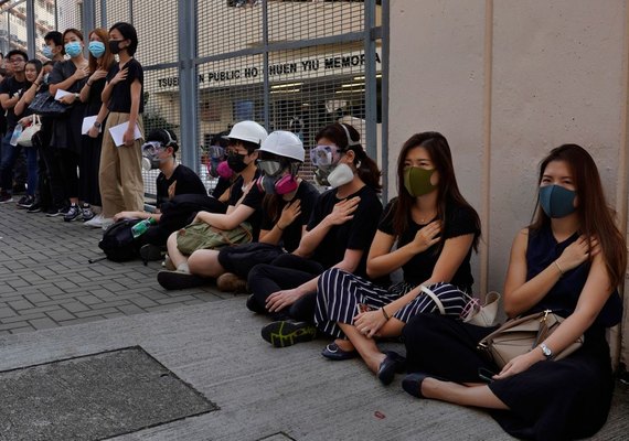 Em frente à escola de jovem baleado em Hong Kong, manifestantes fazem protesto