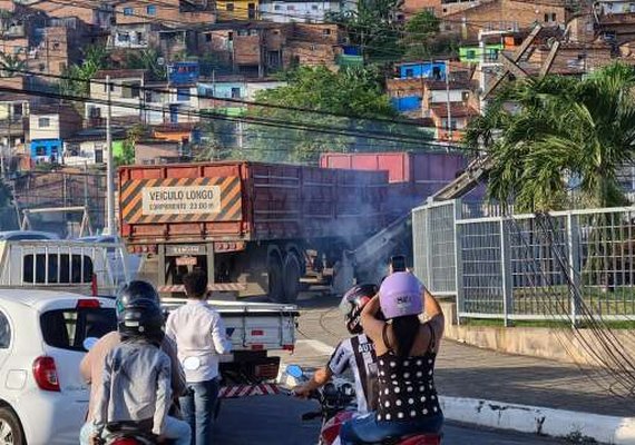 Carreta bate em poste, que cai em parte de estrutura de loja e motorista foge do local