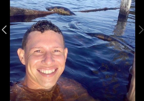 Jovem arrisca 'selfie' com cobra anaconda em rio no AM, e foto viraliza