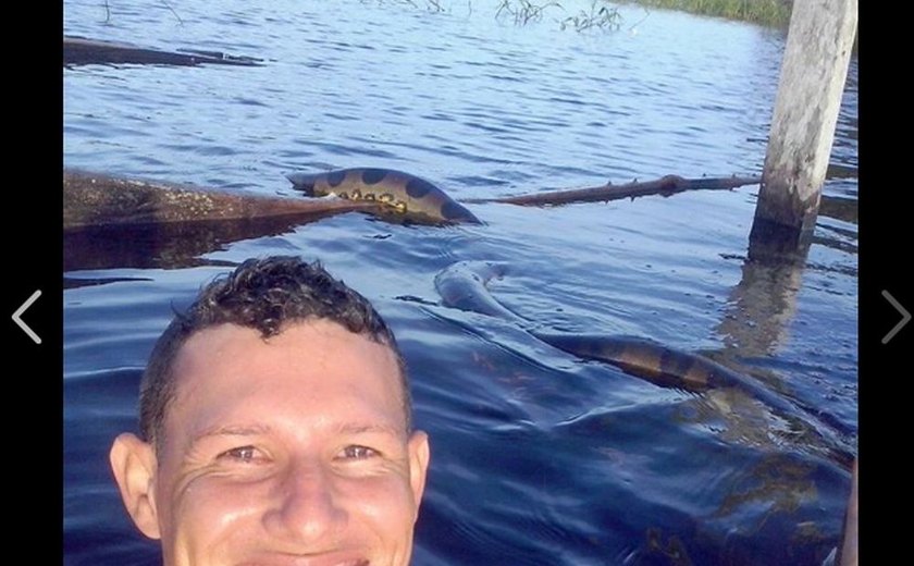 Jovem arrisca 'selfie' com cobra anaconda em rio no AM, e foto viraliza