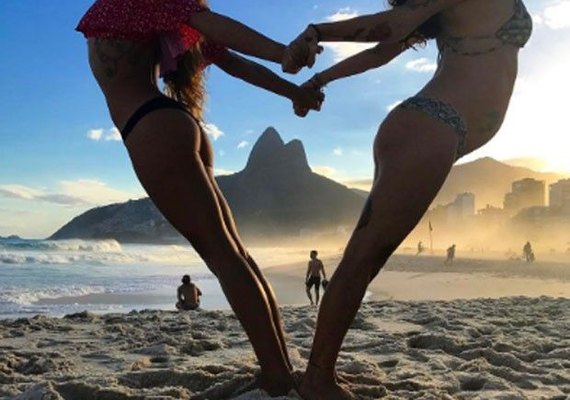 Isis Valverde faz pose de Ioga com amiga grávida na praia