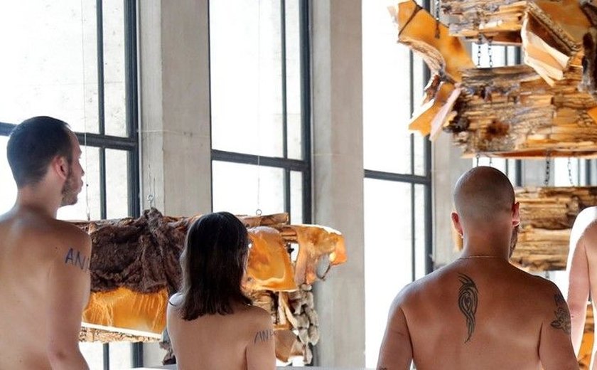 Grupo de nudistas visita museu em Paris