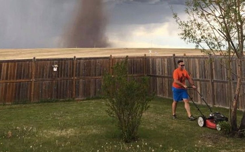 Homem corta grama tranquilamente durante passagem de tornado no Canadá