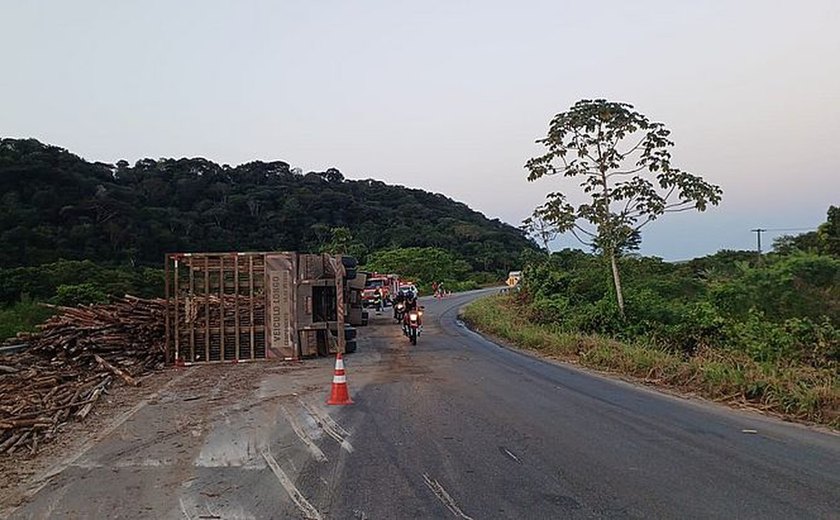 Caminhão carregado com toras de madeira tomba na AL-413 e condutor fica ferido