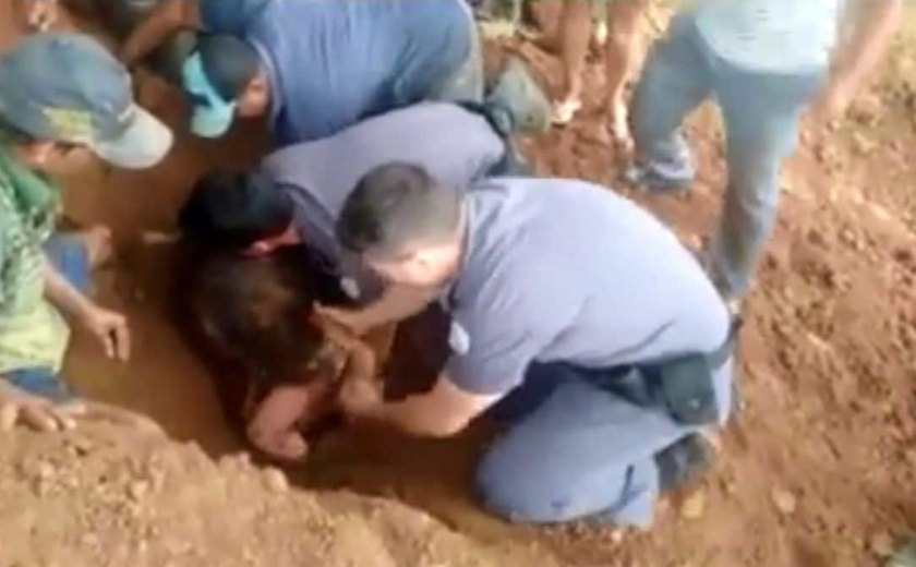 Cavando com as mãos, PMs resgatam menina soterrada