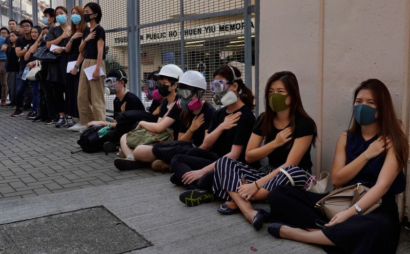 Em frente à escola de jovem baleado em Hong Kong, manifestantes fazem protesto